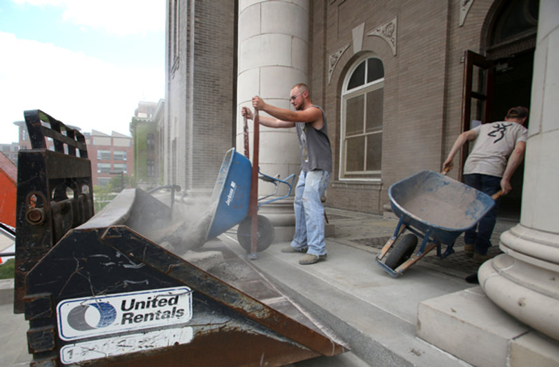 Tracy Burdick and Anthony Magill, both construction workers, work off the steps of Carnegie Library on Monday.