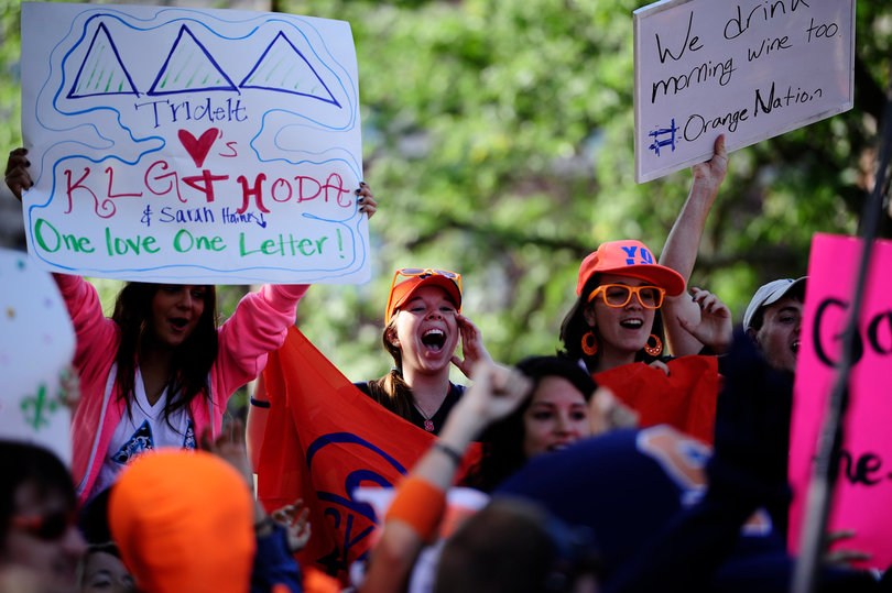 Molly Nelson (center), a junior broadcast and digital journalism major, yells in the crowd.