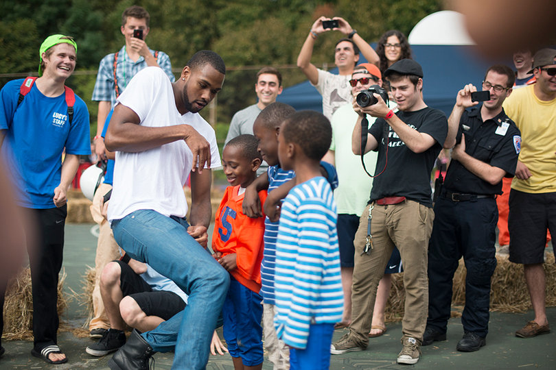 James Southerland, a forward on the SU basketball team, dances with local kids during a "halftime" dance off.  