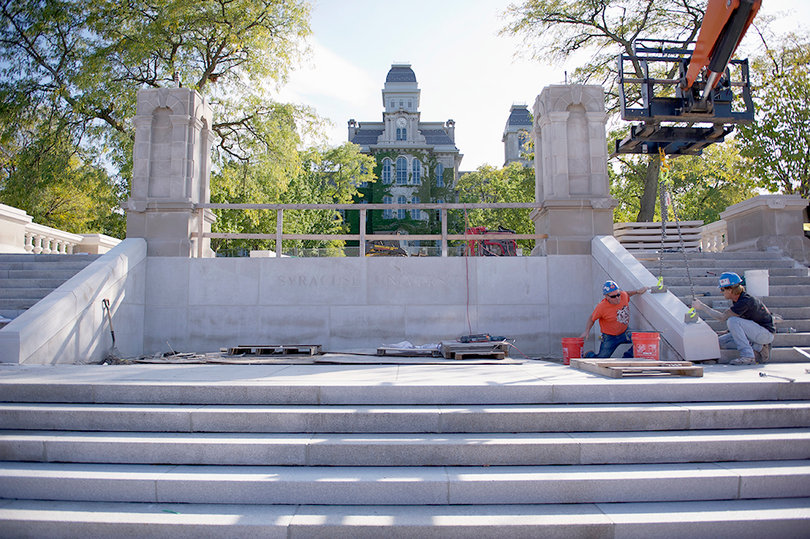 Construction workers finish the stairs of the Place of Remembrance being reconstructed this semester. Names of the 35 SU students killed in  the Pan Am 103 bombing will be re-inscribed on the Wall of Remembrance, which has been constructed with a more durable limestone.