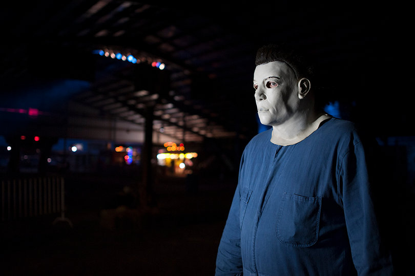 An employee at Fright Nights at the Fair prepares to scare passers-by. This year, Syracuse University worked with the fair for the second time to provide transportation. 