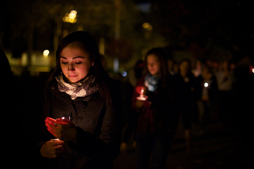 Claire Dorrance, a Lockerbie Scholar from Scotland, kindles her flame while leading participants in the candlelight vigil to the Wall of Remembrance.
