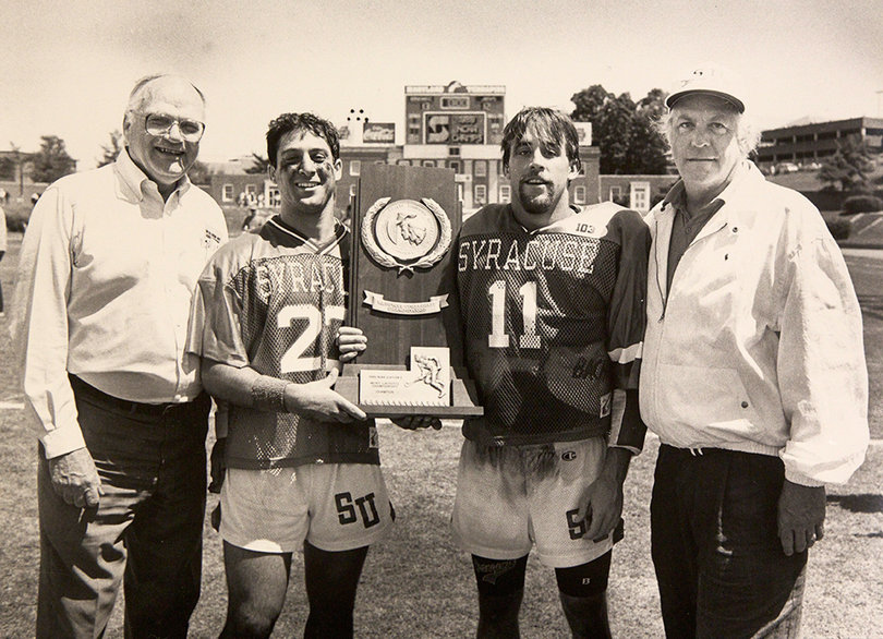 Chancellor Melvin Eggers, Gait, John Zulberti, and Roy Simmons, Jr. display their trophy at the NCAA Division I Men’s Lacrosse Championship in 1989. 
