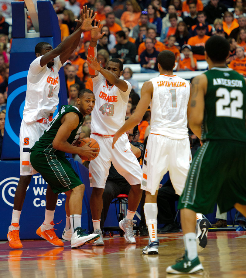 Syracuse center Baye Moussa Keita (left) and James Southerland stick their arms up to double-team a Wagner player in the paint.