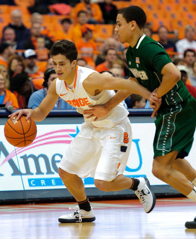 Syracuse guard Nolan Hart dribbles around a defender.