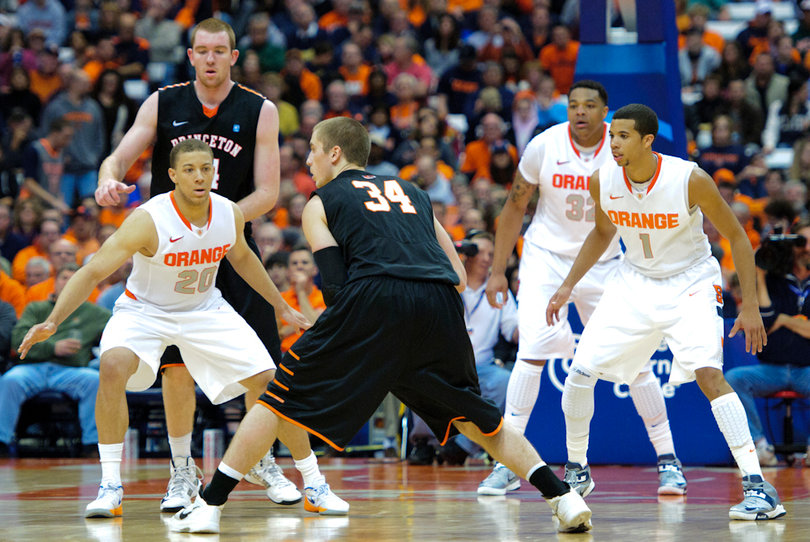 Syracuse's 2-3 zone defense, led by Brandon Triche (20) and Michael Carter-Williams (1) at guard, sets itself up in place as Ian Hummer holds the ball at the top of the arc.