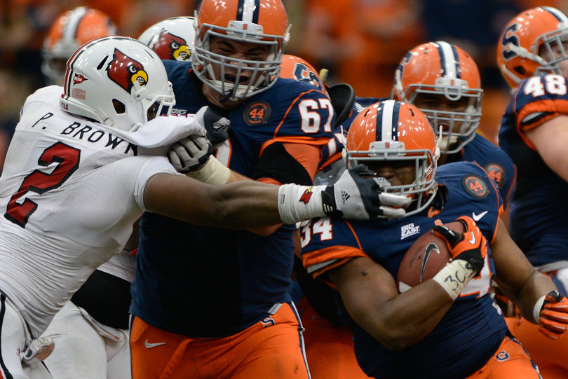 Syracuse running back Adonis Ameen-Moore has his facemask yanked by Louisville's Preston Brown in the Orange's 45-26 upset win.