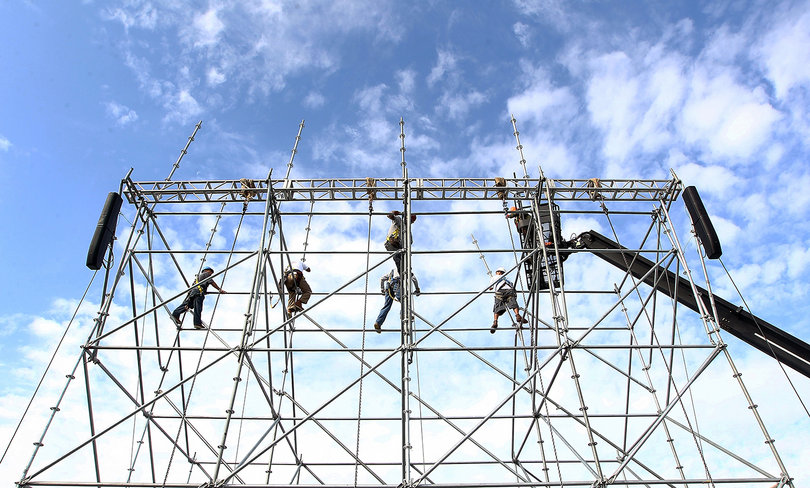 Workers are seen assembling scaffolding to hold video screens aboard the USS Midway Museum on Nov. 8, 2012, before the Battle on the Midway game between the Syracuse Orange and the San Diego State Aztecs scheduled for Sunday.