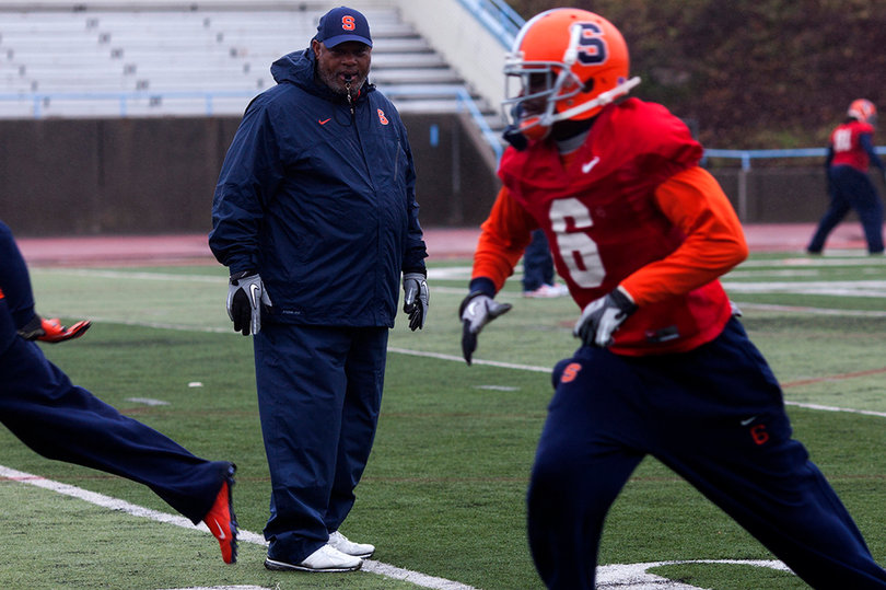 Syracuse secondary coach Donnie Henderson looks over at safety Ritchy Desir during practice.