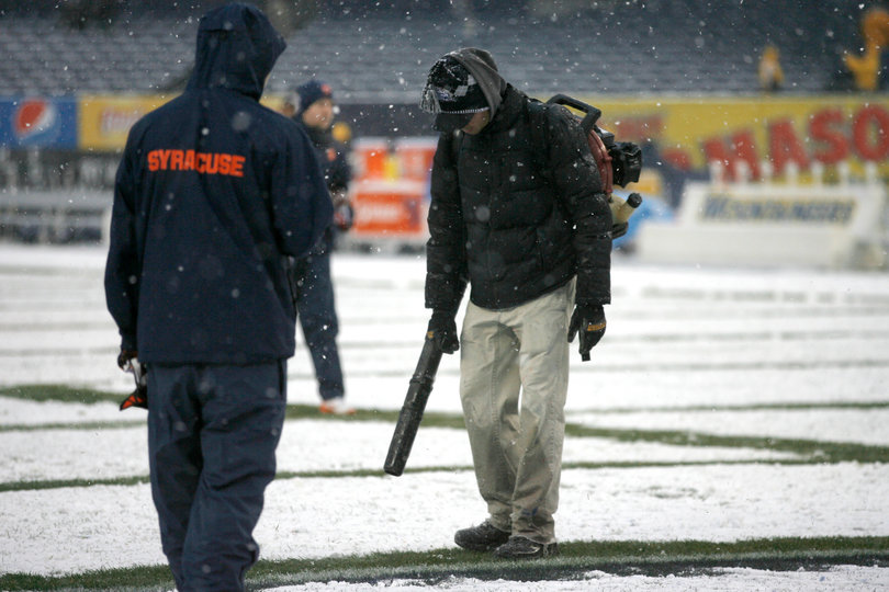 Yankee Stadium staff blows snow from the field. Syracuse takes on West Virginia in the 2012 Pinstripe Bowl at a snowy Yankee Stadium on Saturday, Dec. 29, 2012, in New York City. 