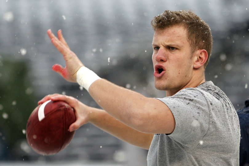 Ryan Nassib passes the ball in blustery conditions on the field before the game.