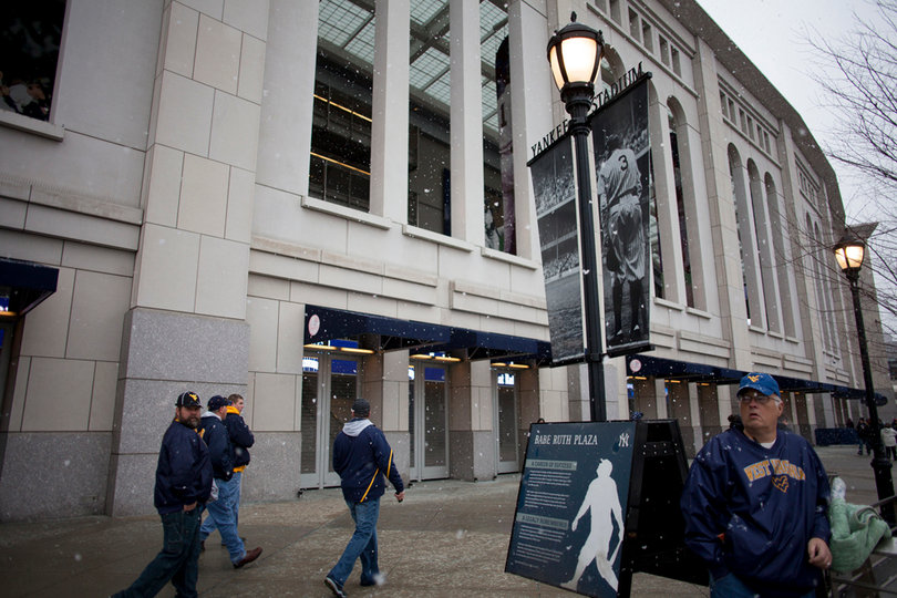 West Virginia fans wait outside in the snow for Yankee Stadium to open to the public. Syracuse takes on West Virginia in the 2012 Pinstripe Bowl at a snowy Yankee Stadium on Saturday, Dec. 29, 2012, in New York City. 