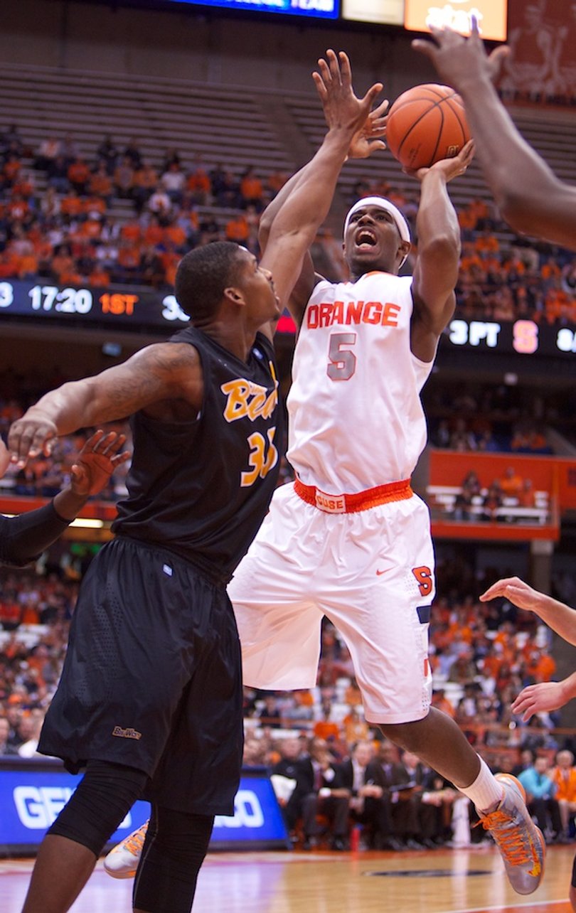 Syracuse University forward C.J. Fair is fouled by Long Beach State's Dan Jennings while shooting a layup during the second half of the Orange's rout of Long Beach State Thursday Night at the Carrier Dome. Fair had one of his best games of the season, registering a double-double with 16 points and 13 rebounds. 