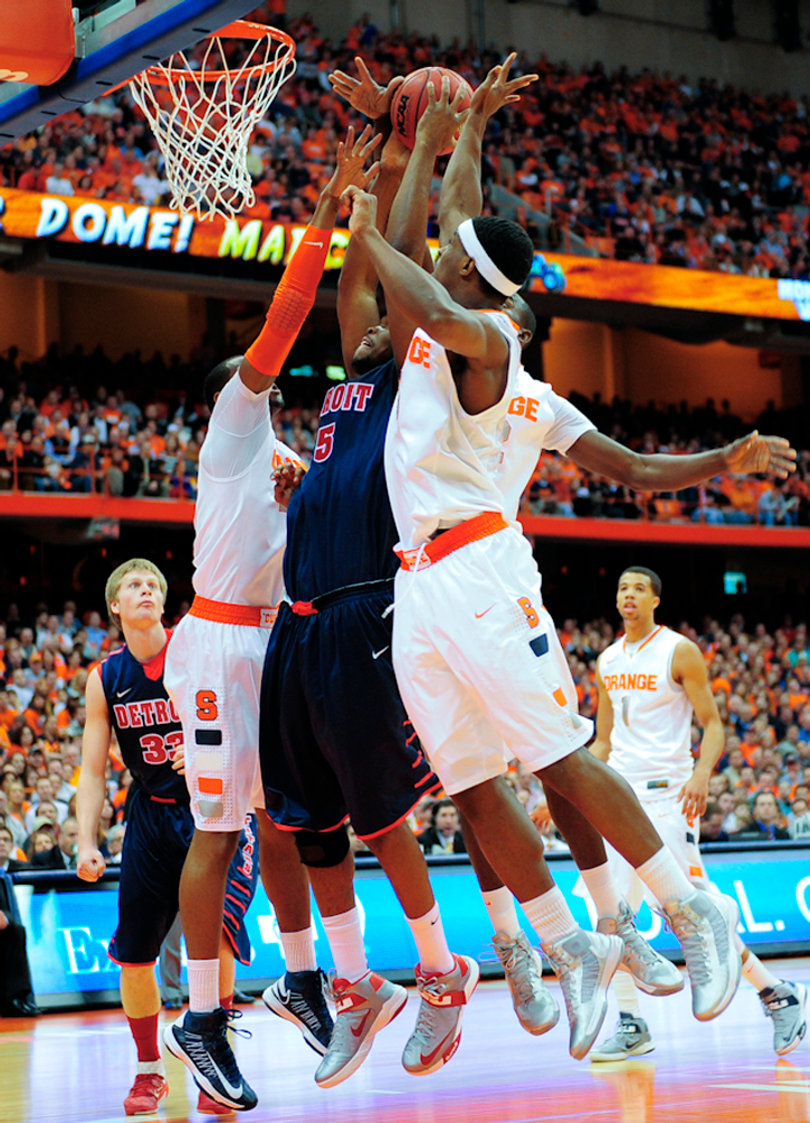 Detroit's Ugochukwu Njoku fights for a rebound amid a clash of Syracuse players.