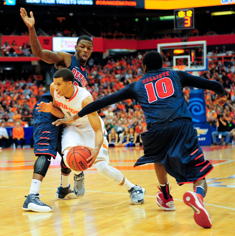 Michael Carter-Williams splits a couple of Detroit defenders as he drives to the basket in Syracuse's win over the Titans.