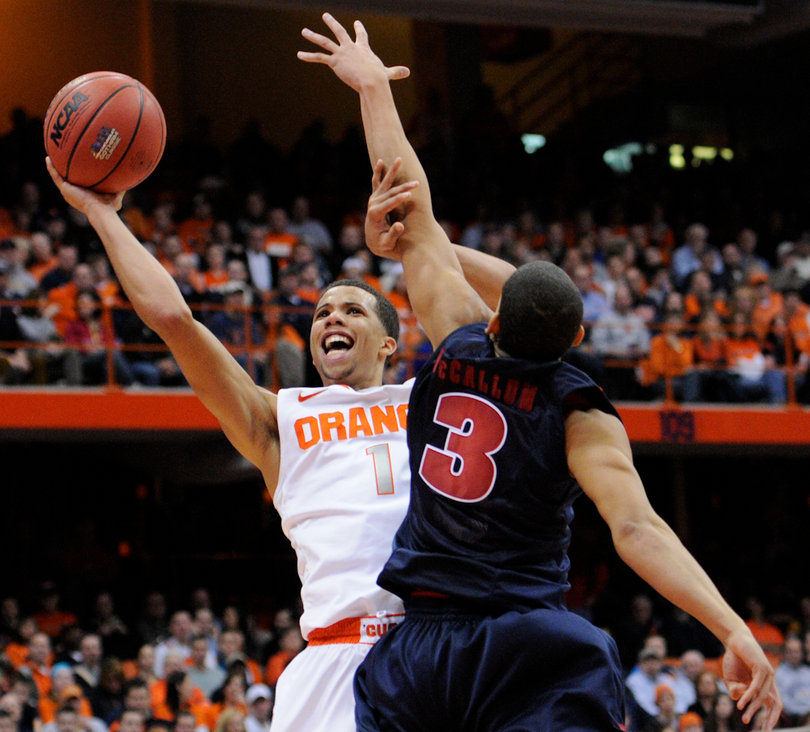 Syracuse guard Michael Carter-Williams attempts a shot while Detroit's Ray McCallum defends. 