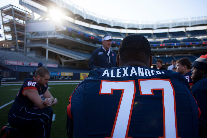 Offensive lineman Lou Alexander (77) listens in as head coach Doug Marrone speaks to his team and area youths at Yankee Stadium.