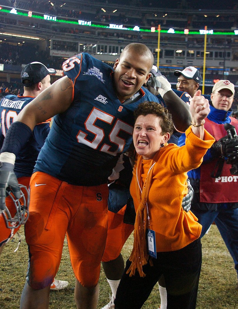 Chancellor Nancy Cantor celebrates with defensive tackle Anthony Perkins after Syracuse defeated Kansas State in the Pinstripe Bowl.