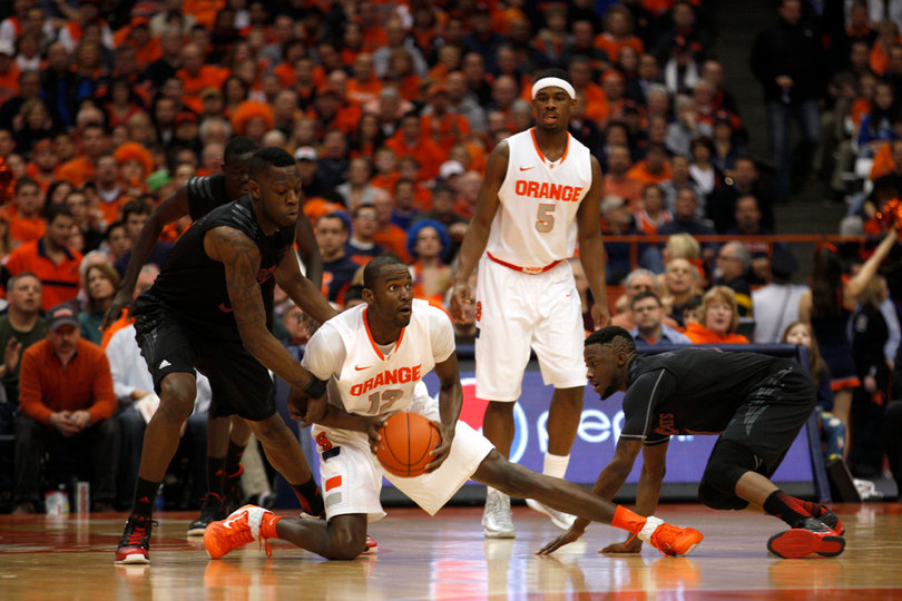 Syracuse center Baye Moussa Keita looks to pass up the court from his knee.