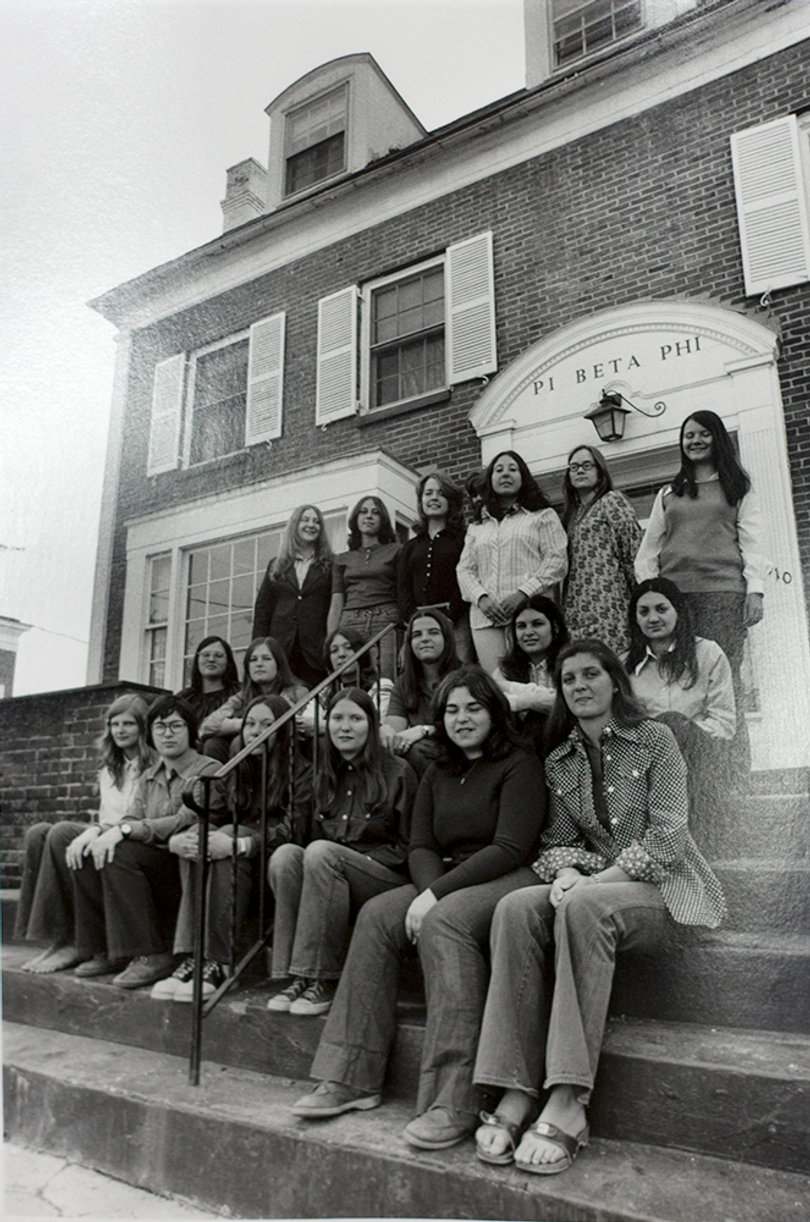 Pi Phi sisters from 1973 pose on the front steps of the current house at 210 Walnut Pl.