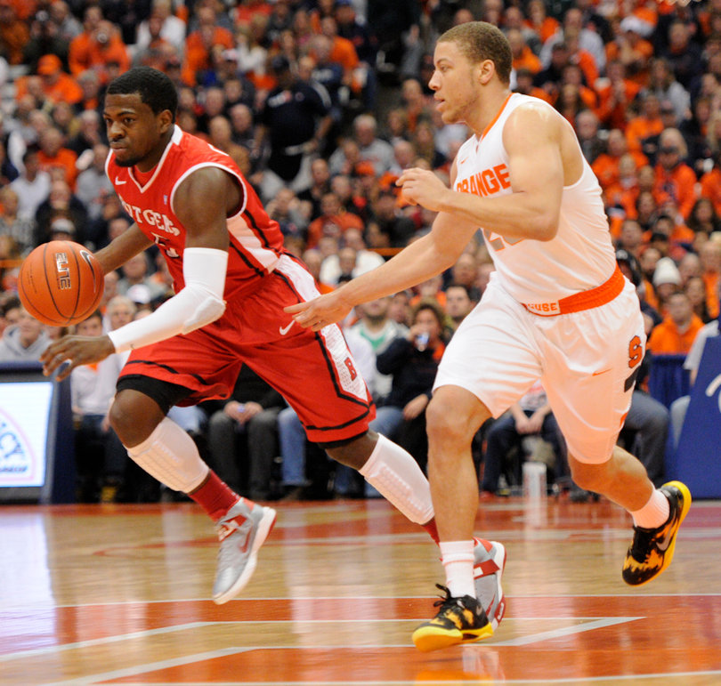 Syracuse guard Brandon Triche defends Scarlet Knights guard Eli Carter.