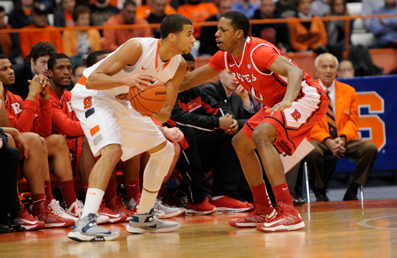 Syracuse guard Michael Carter-Williams looks to pass past Rutgers guard Mike Poole.