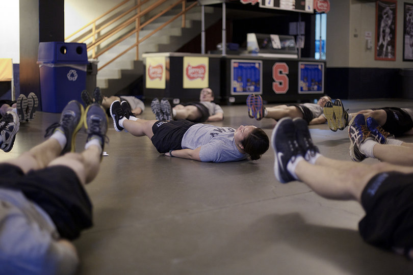 Elizabeth Kang, a junior health and exercise science major, leads her battalion in leg raises during Monday morning workouts in the Carrier Dome. 