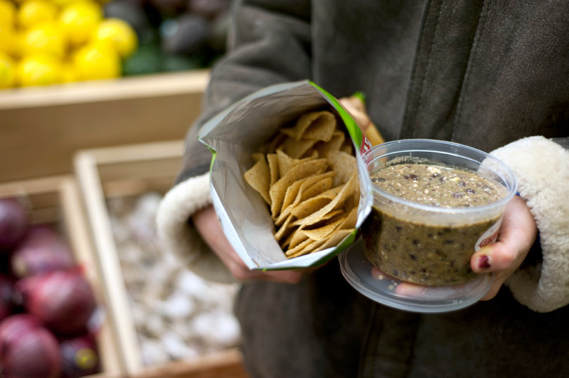 The local grocery store offers free samples to shoppers, such as this homemade Super Black Bean Dip and mass-produced chili-lime tortilla chips.