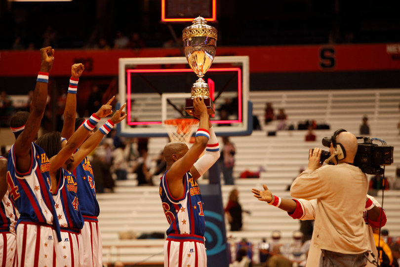 Scooter raises the World Cup Championship trophy while his teammates celebrate in the background. 