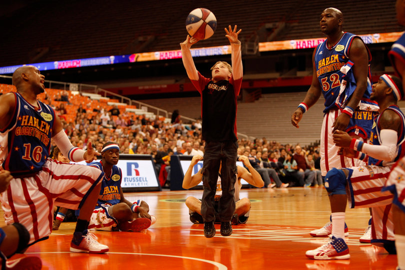 Scooter, Big Easy and other players look on, praying for the volunteer's shot to find a way into the basket. 