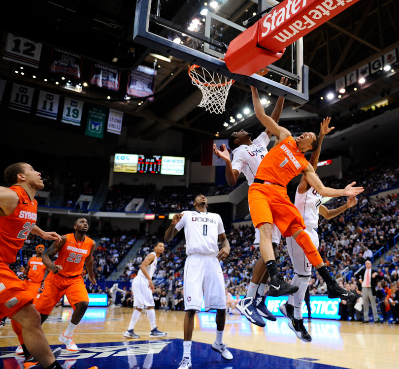 Syracuse point guard Michael Carter Williams gets bumped on a layup attempt as his teammates look on.
