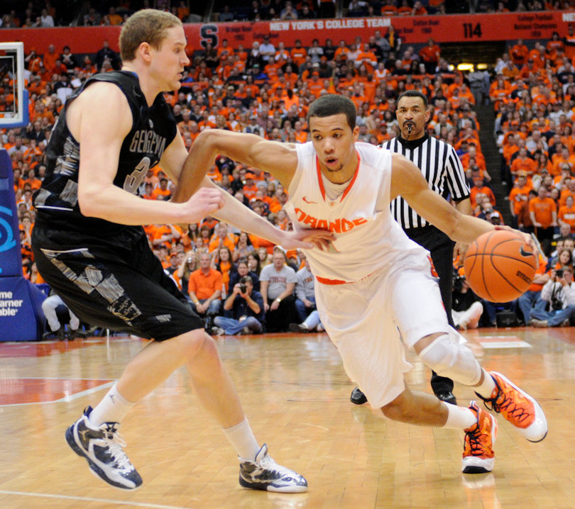 Michael Carter-Williams drives past Nate Lubick.