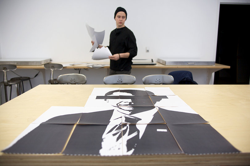 G Clay Miller, a freshman political science major, works on some political pieces, creating the images and taping them together before hanging them in Shaffer Art Building.