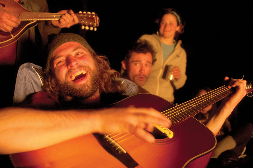 Joe Sullivan, a junior at SUNY-ESF, serenades the Syracuse University Outing Club around a campfire while on spring break in West Virginia. 