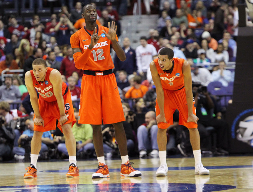 Baye Moussa-Keita #12 of the Syracuse Orange signals to teamates from the court as he stands next to Brandon Triche #20 and Michael Carter-Williams #1 in the game against the Indiana Hoosiers.