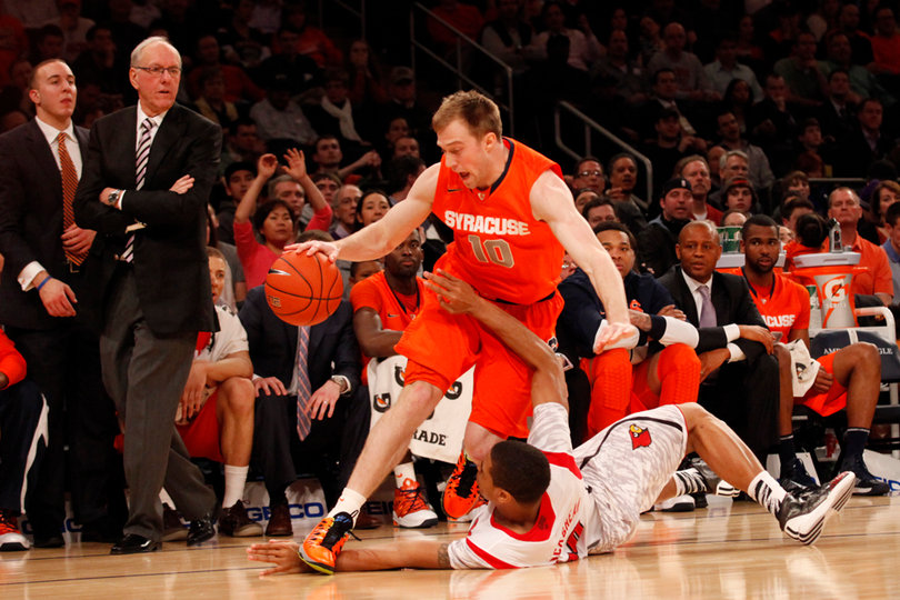 Trevor Cooney drives the ball over Louisville's Wayne Blackshear (#20).