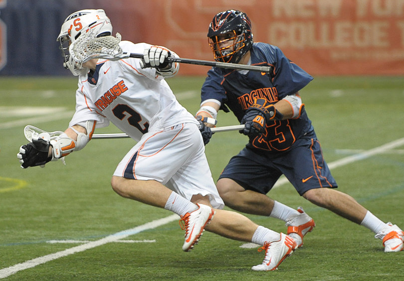 Syracuse attack Kevin Rice runs past Virginia long-stick midfielder Tanner Ottenbreit.