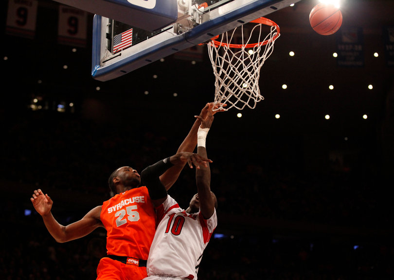 Rakeem Christmas goes for a defensive rebound in the paint against Louisville's Gorgui Dieng (#10).