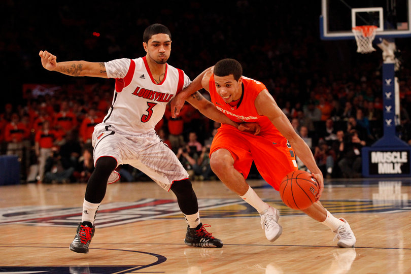 Michael Carter-Williams drives the ball into the paint past Louisville's Peyton Siva (#3)