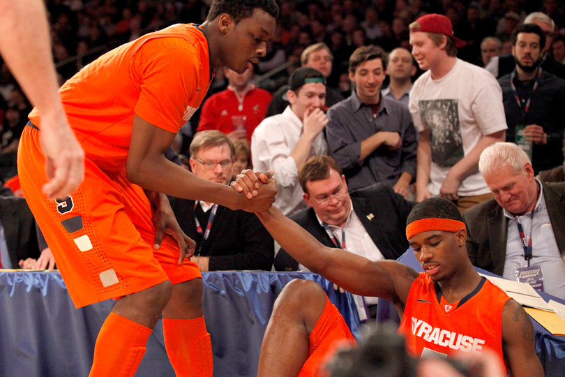 Missing the rebound, C.J. Fair flies off the court, falling onto spectators. Jeremy Grant lifts Fair off the ground.
