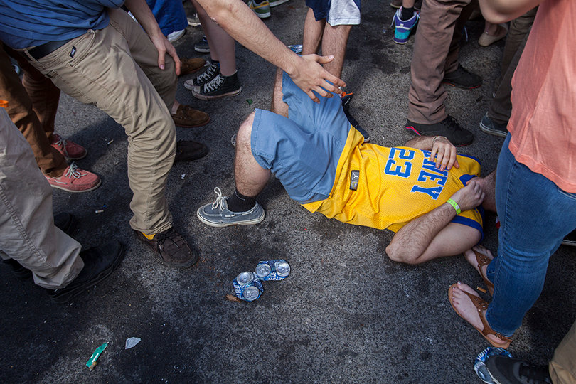 A party goer is helped up after falling to the ground, Friday afternoon at Castle's Court.