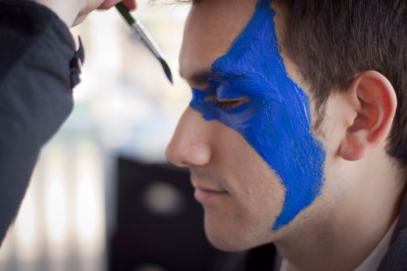 Joshuah Romero, a junior and staff photographer, gets his face painted Michigan colors on Thursday afternoon.