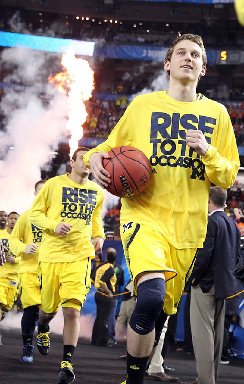 Nik Stauskas and the Michigan Wolverines run onto the court.