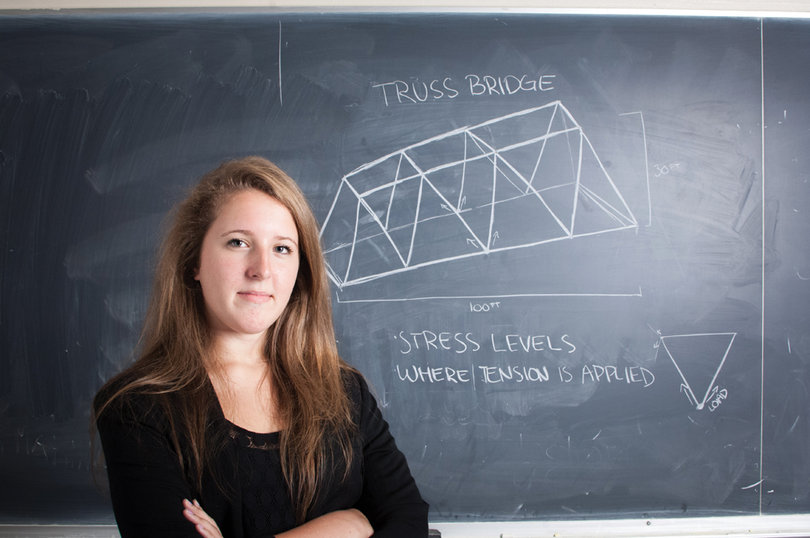 Michelle Dube  with a diagram of a basic truss bridge she built in ECS 101.