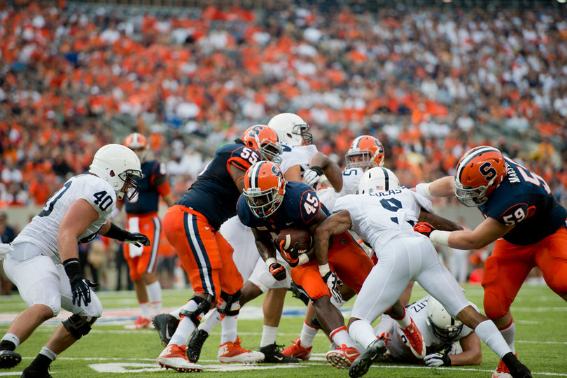 Syracuse running back Jerome Smith runs up the middle, trying to burst by Penn State's Jordan Lucas. 