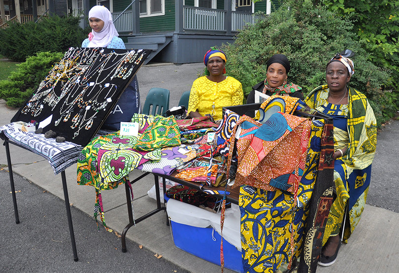(From left) Tamoni Sumaicli, Kiza Useni and Makene Yelusa, Syracuse residents and members of Umoja Ya Wamama Women United, sell colurful East African sewing pillows, bags and skirts.