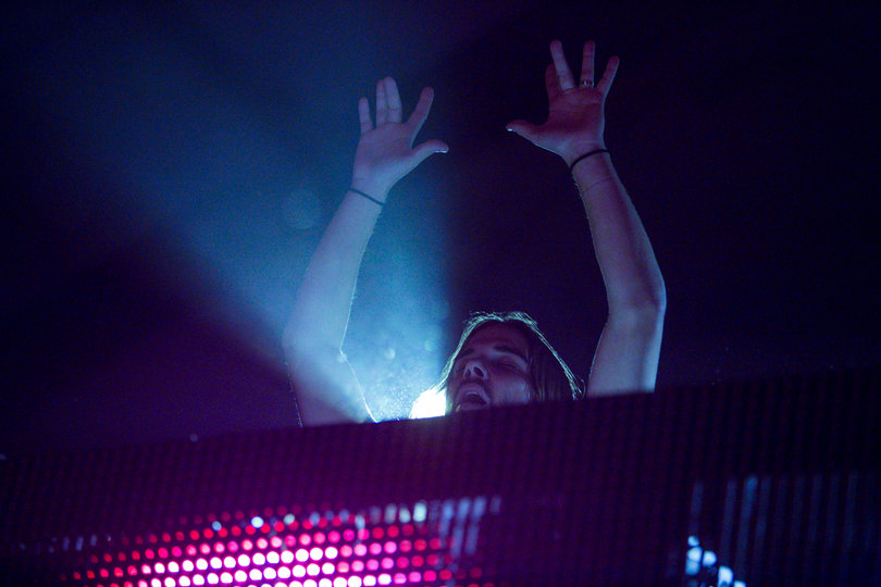 Seven Lions raises his hands after taking the stage.