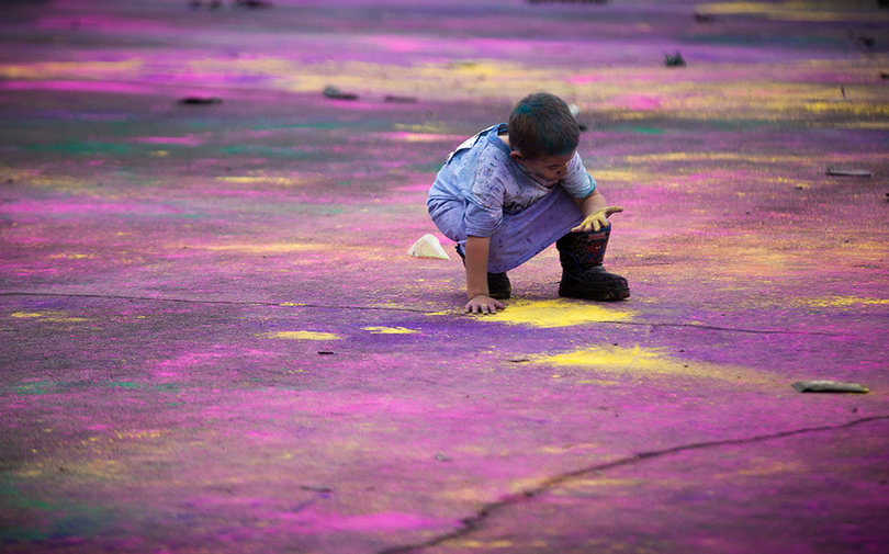 Damian lawson smears remnants of yellow powder into the ground at the finish line after runners started leaving. People of all ages joined the race.