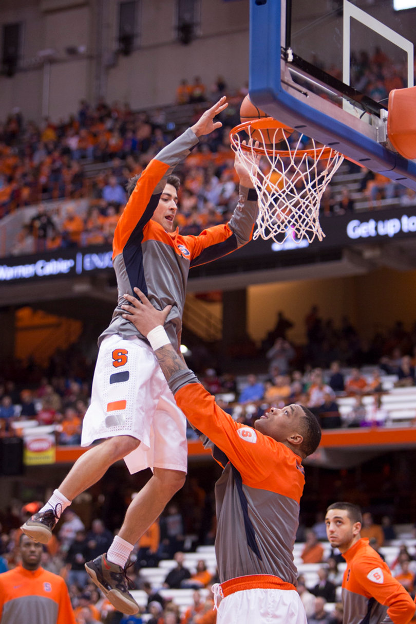 Center DaJuan Coleman hoists Nolan Hart to the rim as part of a team ritual prior to the pregame huddle.  