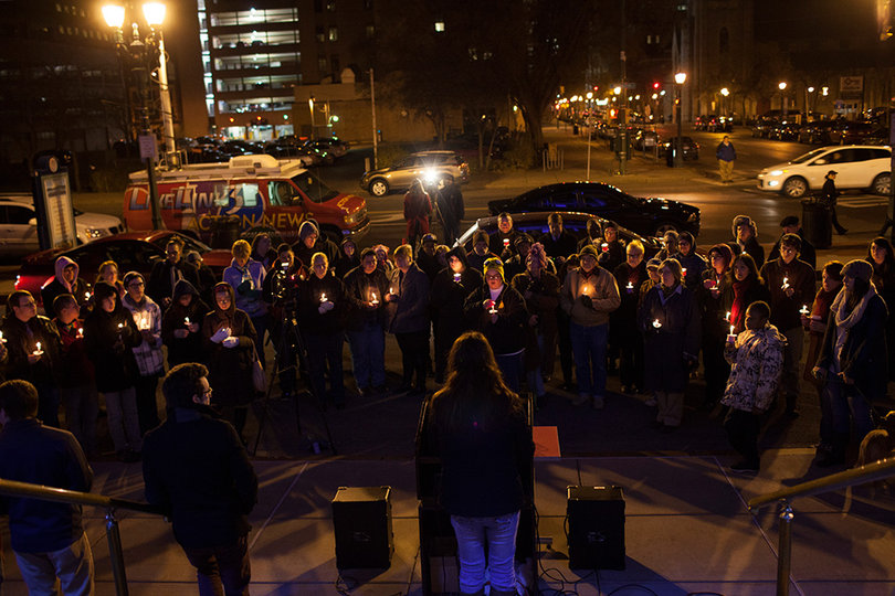 People hold candles outside Syracuse City Hall during a ceremony held for those in the transgender community killed this year.
